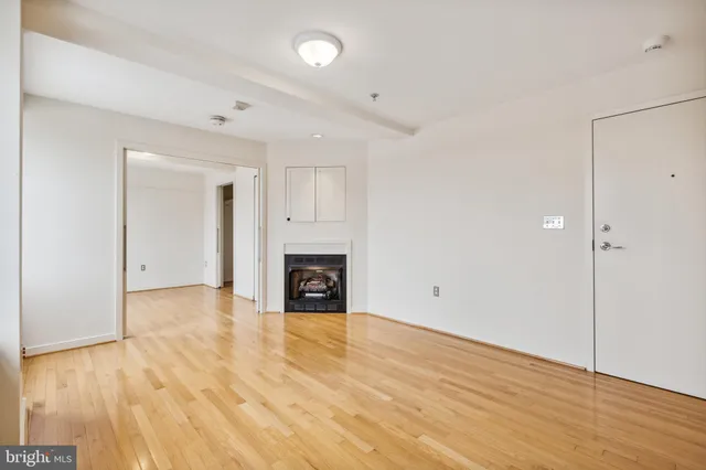 a view of empty room with wooden floor and fireplace