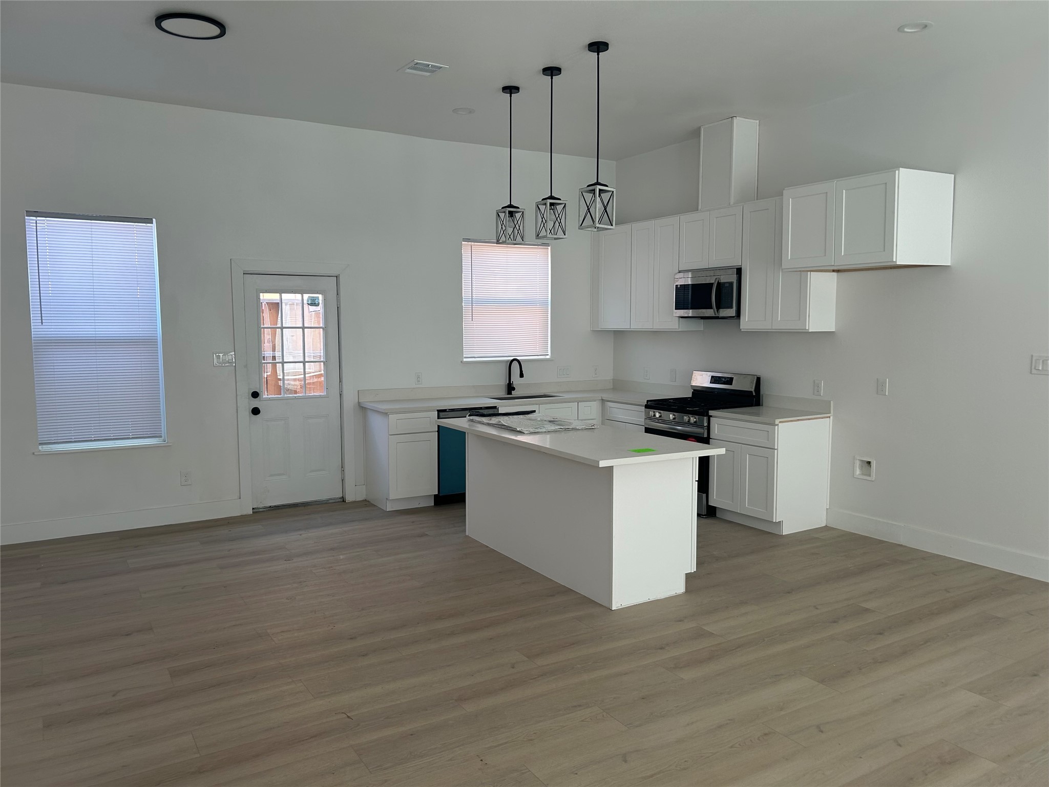8203 Sparta Street, Unit B Houston, TX 77028 - Photo 4 of 12 a kitchen with stainless steel appliances kitchen island granite countertop a stove a sink and white cabinets