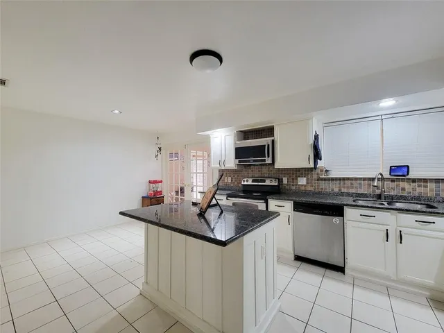 a kitchen with stainless steel appliances granite countertop a sink dishwasher stove top oven and cabinets