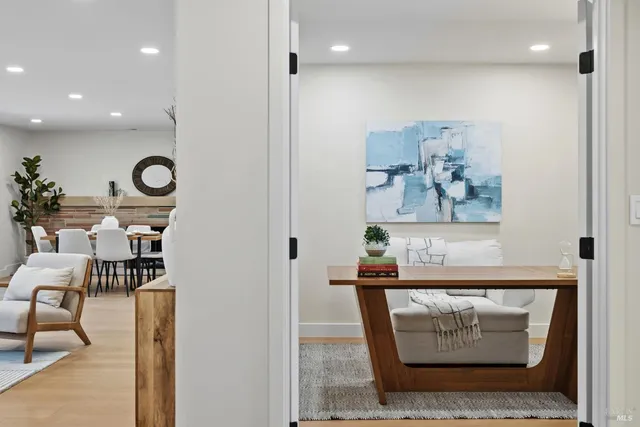 a living room with furniture and a painting on the wall