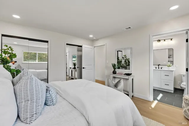 a bedroom with a large bed and a chandelier