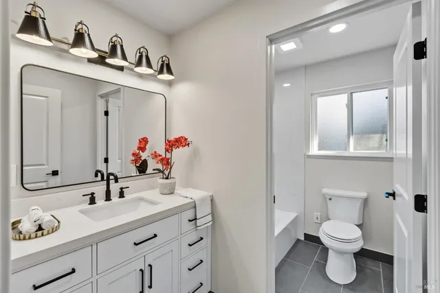 a bathroom with a toilet sink and mirror