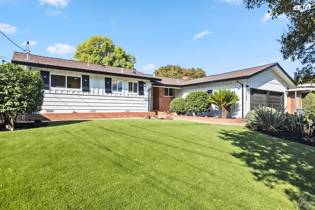 a front view of house with yard and green space
