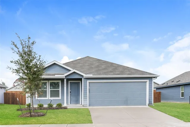 a front view of a house with a garden and yard