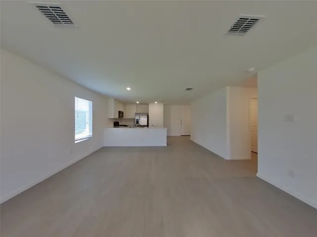 a view of empty room with window and wooden floor