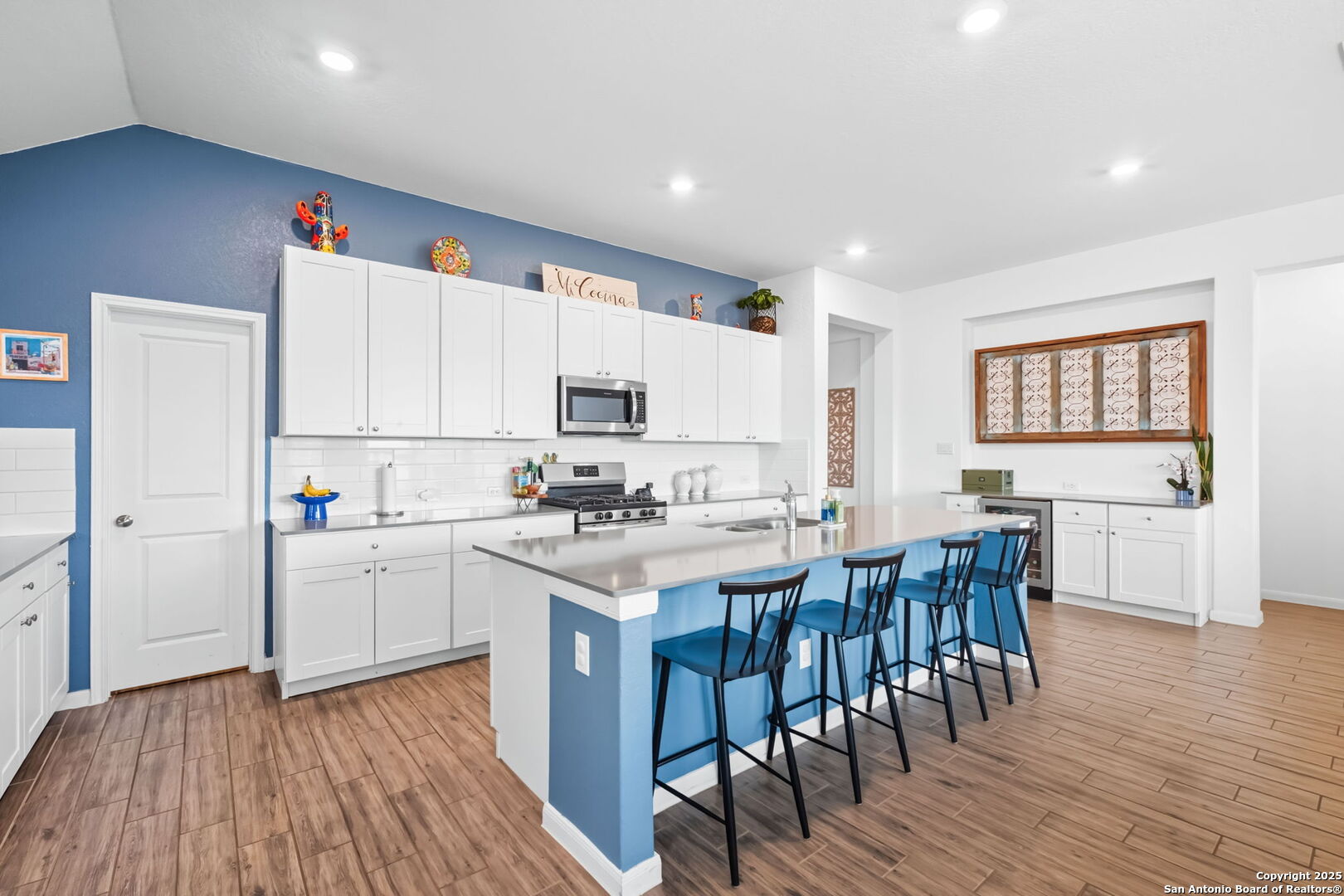 8950 Rancher Place Seguin, TX 78155 - Photo 4 of 34 a kitchen with cabinets a sink dishwasher a dining table and chairs with wooden floor