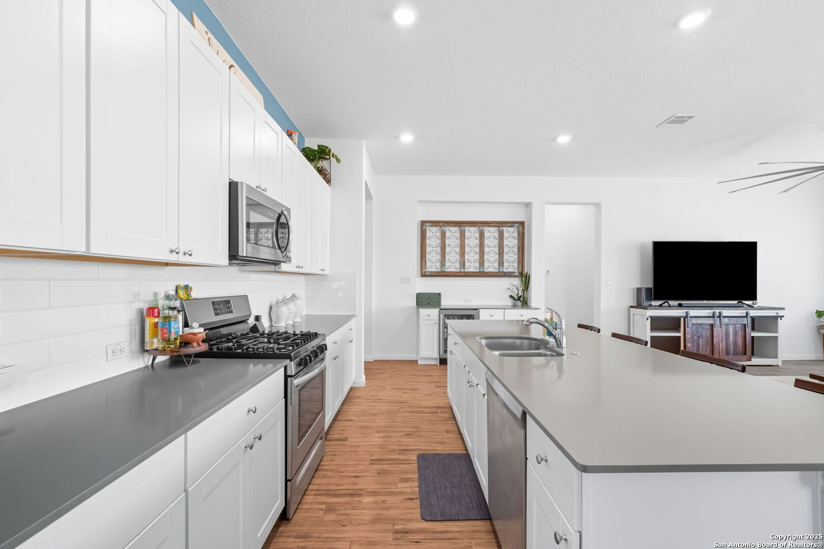 8950 Rancher Place Seguin, TX 78155 - Photo 6 of 34 a kitchen with stainless steel appliances a stove a sink a microwave a refrigerator and cabinets