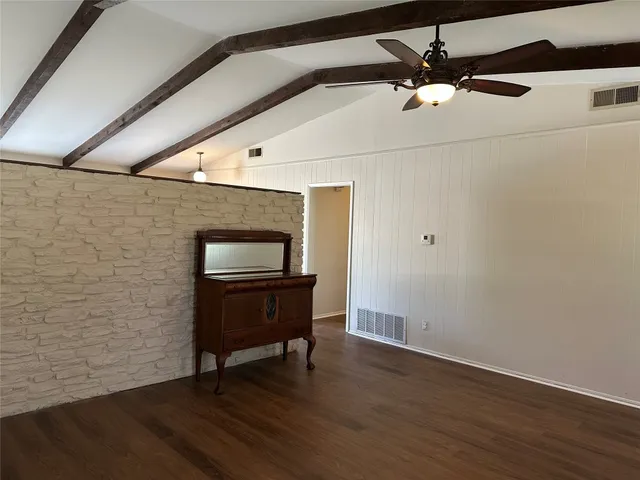 a view of a hallway with wooden floor and black white walls