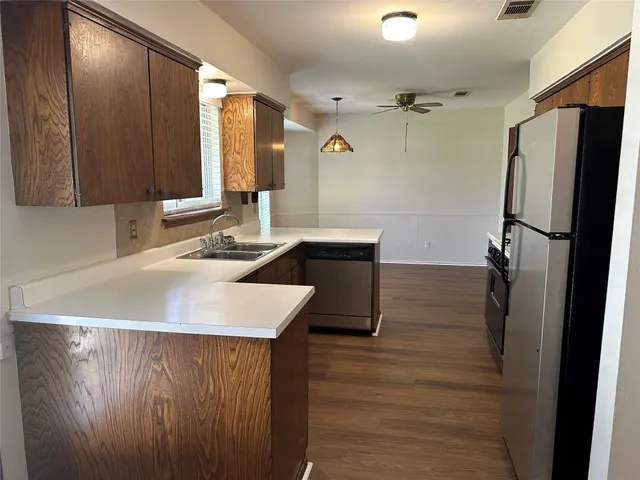 a kitchen with a sink a refrigerator and a mirror