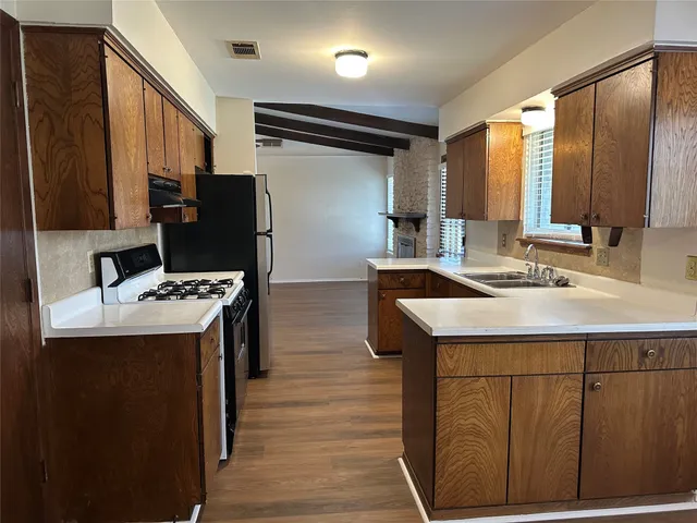 a kitchen with stainless steel appliances kitchen island a sink stove and refrigerator