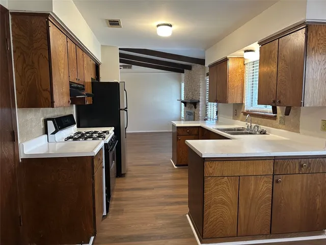 a kitchen with stainless steel appliances kitchen island a sink stove and refrigerator