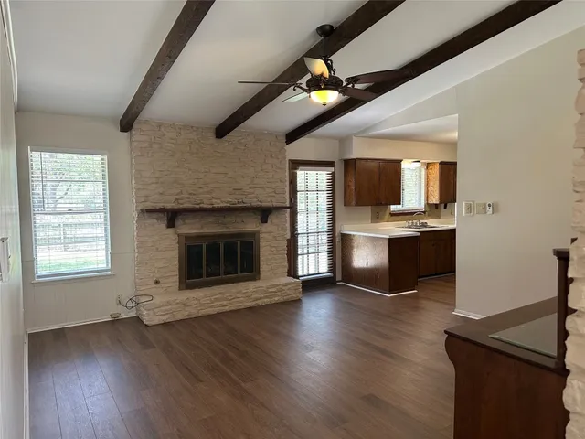 a view of kitchen with microwave a stove and wooden floor