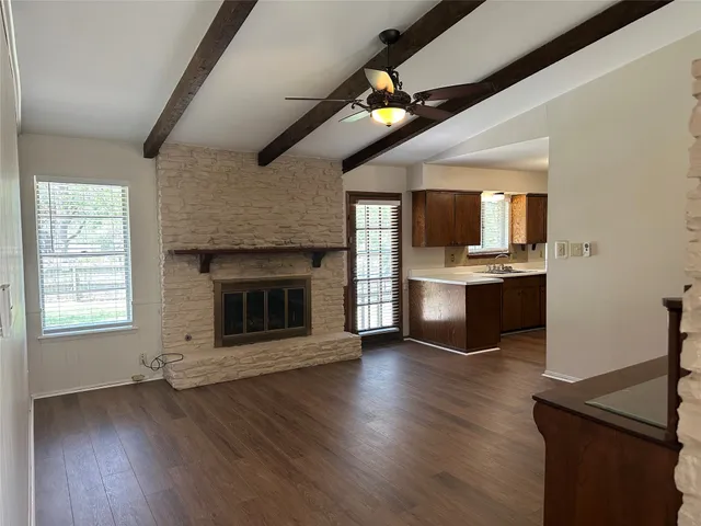 a view of kitchen with microwave a stove and wooden floor