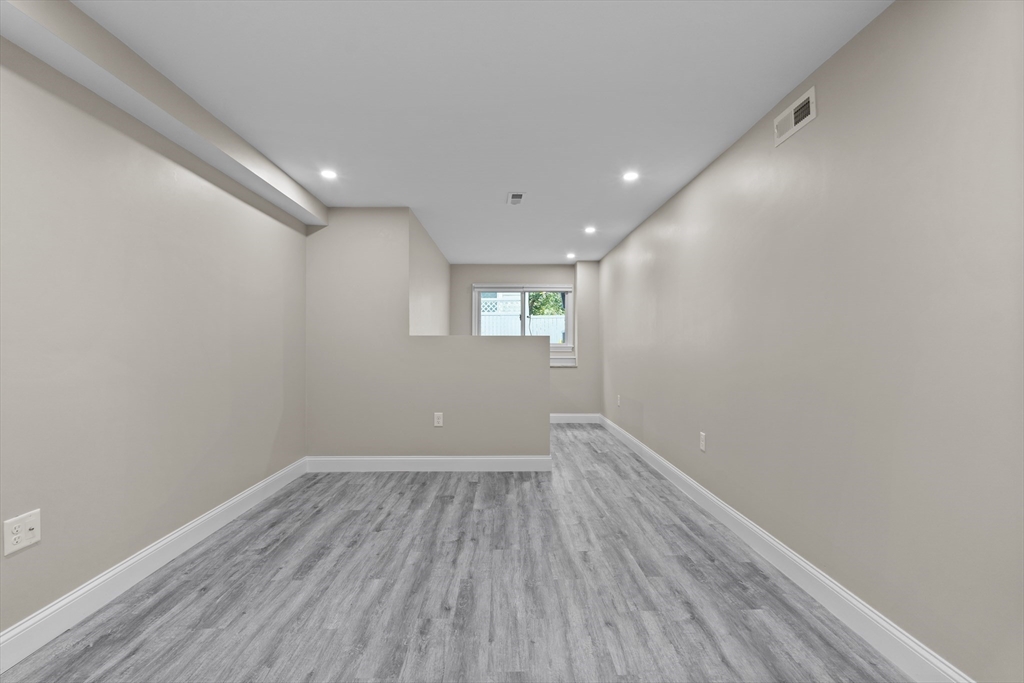 769 East 6th Street, Unit 1 Boston, MA 02127 - Photo 11 of 18 a view of wooden floor and windows in an empty room