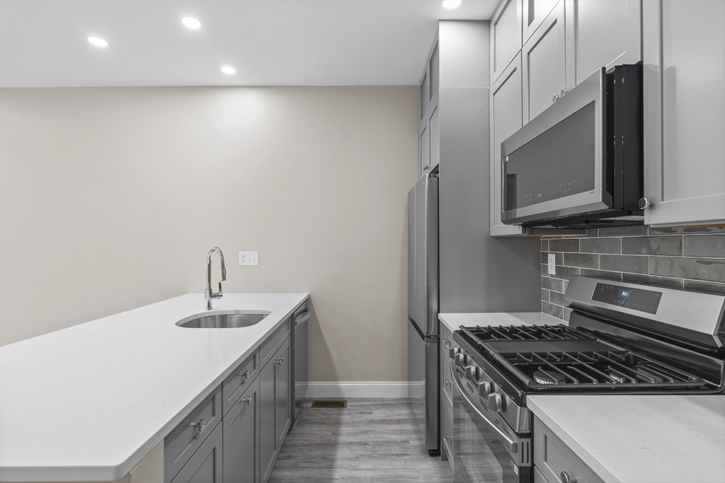 769 East 6th Street, Unit 1 Boston, MA 02127 - Photo 2 of 18 a kitchen with stainless steel appliances a sink a stove and a microwave