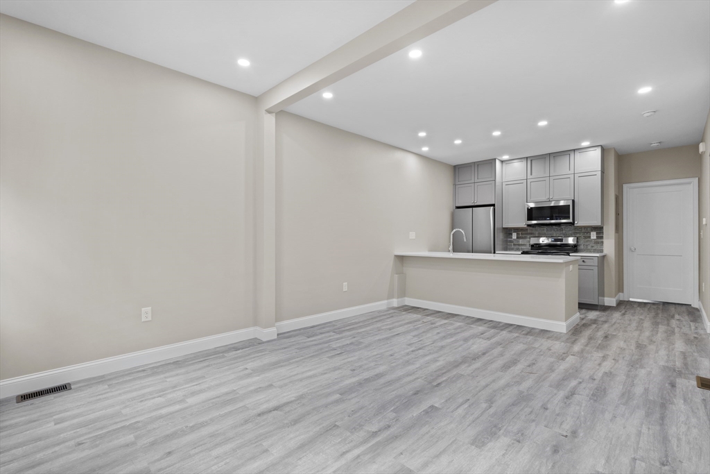 769 East 6th Street, Unit 1 Boston, MA 02127 - Photo 3 of 18 a view of kitchen with kitchen island wooden floor center island and stainless steel appliances