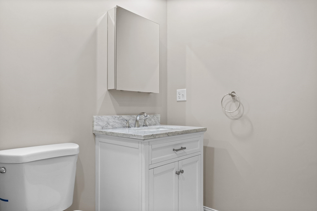 769 East 6th Street, Unit 1 Boston, MA 02127 - Photo 8 of 18 a bathroom with a granite countertop toilet and a sink