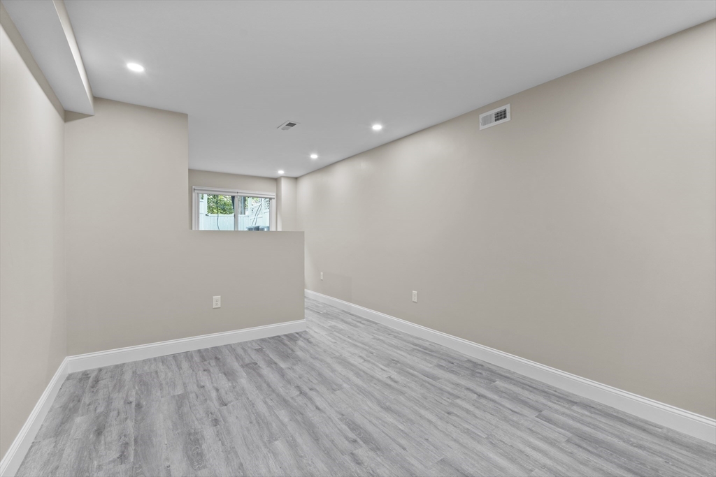 769 East 6th Street, Unit 1 Boston, MA 02127 - Photo 10 of 18 wooden floor in an empty room with a window