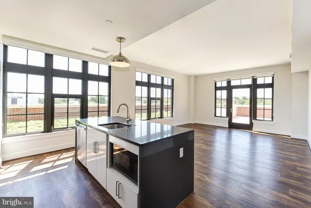 a kitchen with stainless steel appliances granite countertop a sink and a refrigerator