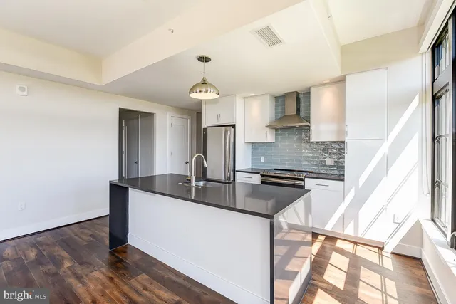 a kitchen that has a sink and a wooden floor