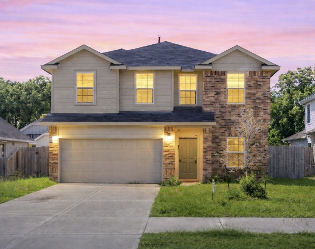 a front view of a house with a yard and garage