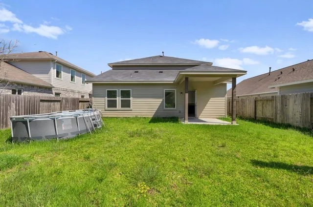 a view of a house with a backyard and a patio