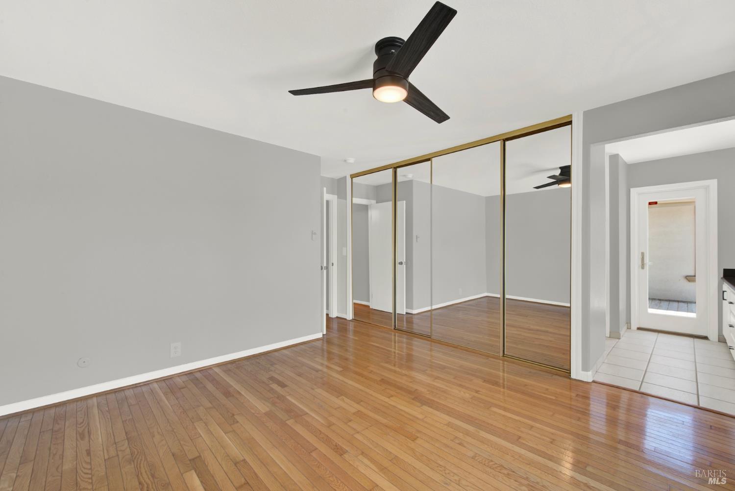 1270 Willow Lake Road Discovery Bay, CA 94505 - Photo 24 of 29 a view of an empty room with wooden floor and a ceiling fan
