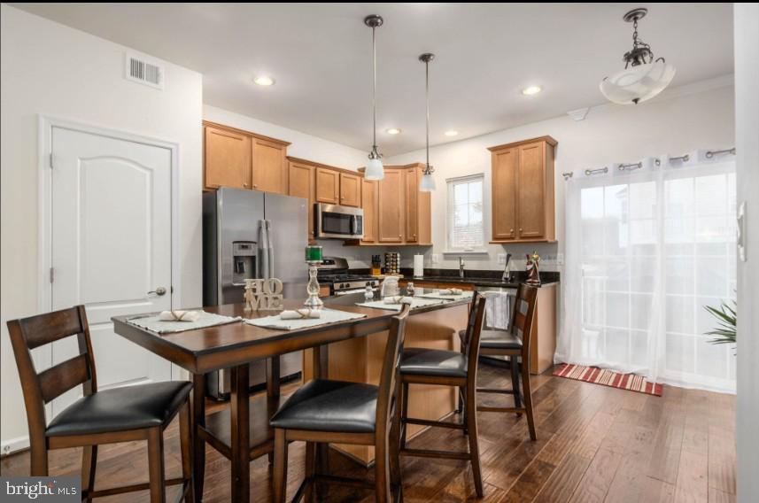 111 Tree Line Drive Fredericksburg, VA 22405 - Photo 14 of 20 a kitchen with stainless steel appliances a dining table chairs refrigerator and cabinets