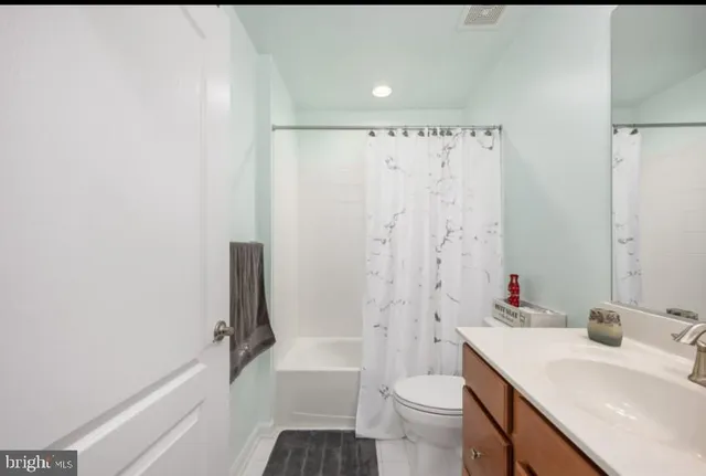 a bathroom with a sink toilet vanity and tub