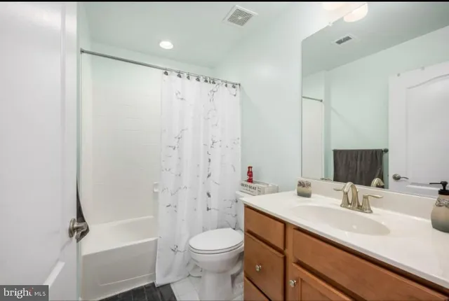 a bathroom with a sink toilet double vanity and shower