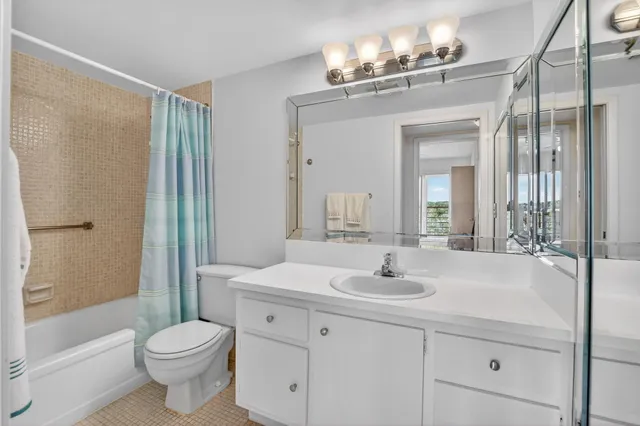 a bathroom with a double vanity sink toilet and a mirror
