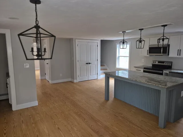 a view of a kitchen with a sink wooden floor and a chandelier