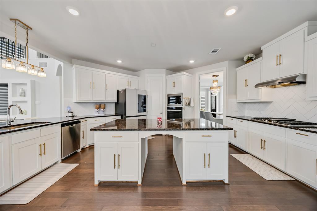 1524 Buckthorn Road Fate, TX 75087 - Photo 21 of 37 a kitchen with stainless steel appliances granite countertop a stove and white cabinets