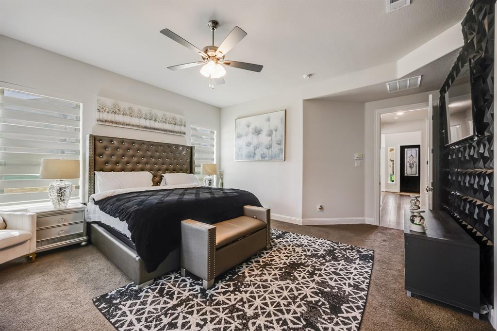 1524 Buckthorn Road Fate, TX 75087 - Photo 25 of 37 a bedroom with a bed and a chandelier