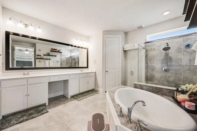 a bathroom with a tub a sink and a shower