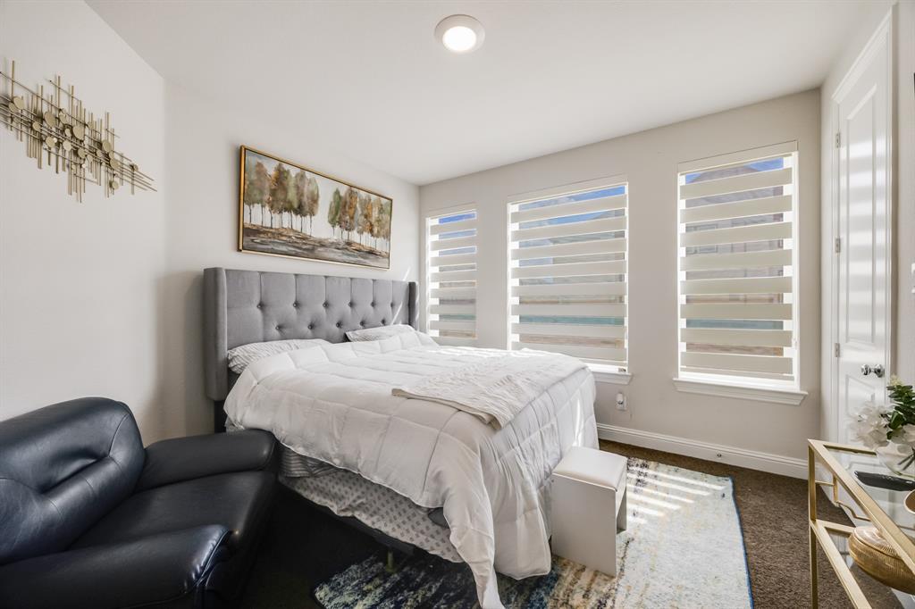 1524 Buckthorn Road Fate, TX 75087 - Photo 35 of 37 a bedroom with a bed a couch and a window