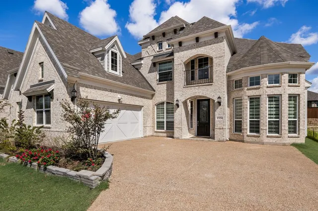 front view of a brick house with a yard