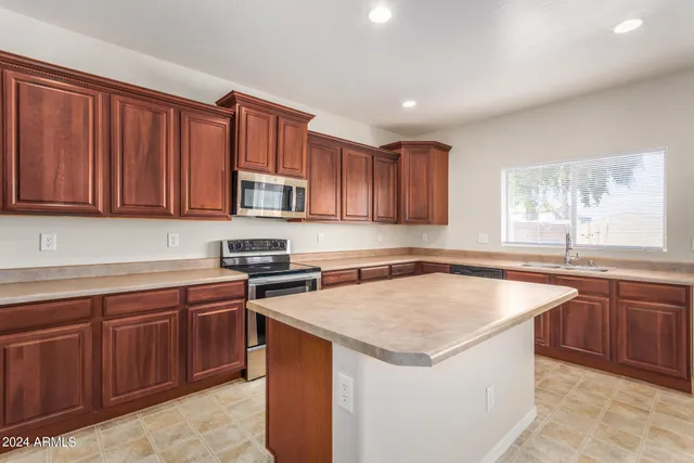 a kitchen with stainless steel appliances granite countertop a stove top oven a sink and dishwasher