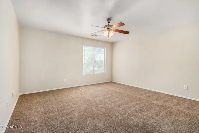 a view of empty room with a ceiling fan