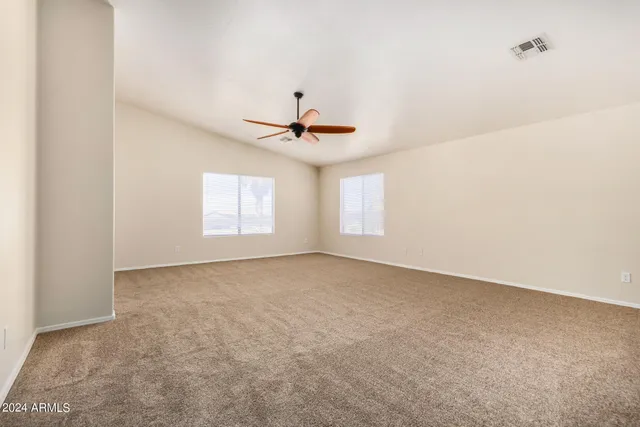an empty room with a window and a fan