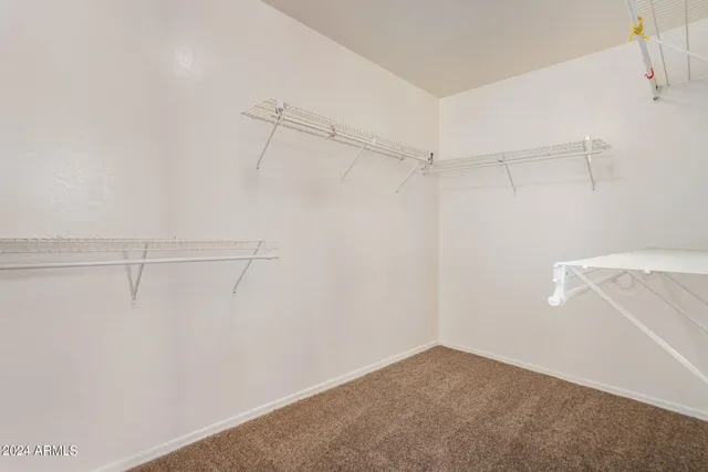 an empty room with closet and a chandelier fan
