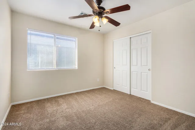 an empty room with chandelier fan
