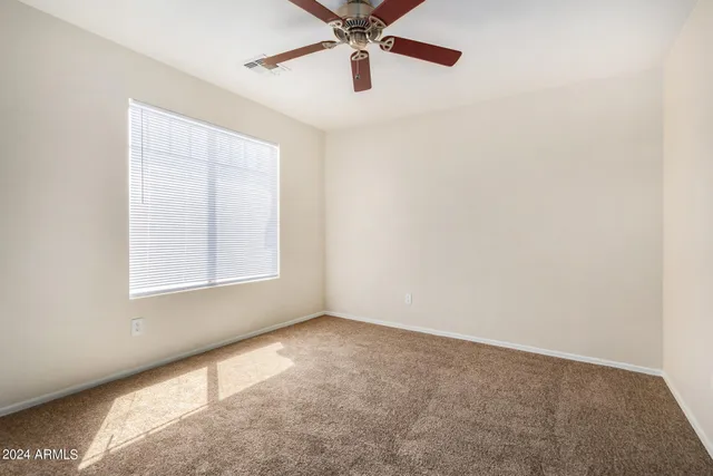 a view of empty room with ceiling fan