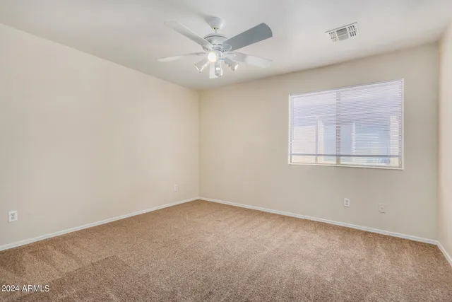 a view of an empty room with a chandelier fan