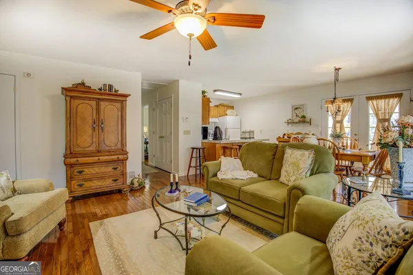 a living room with furniture a chandelier and a flat screen tv