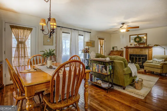 a kitchen with stainless steel appliances granite countertop a refrigerator a sink a stove and white cabinets with wooden floor