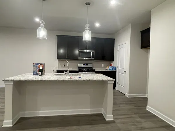 a kitchen with kitchen island a sink stainless steel appliances and cabinets