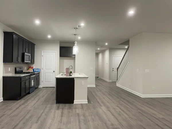 a kitchen with a sink and wooden floor