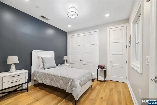 a bedroom with a bed and painting on the wall