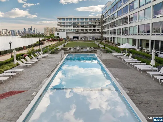 a view of swimming pool with outdoor seating and city view